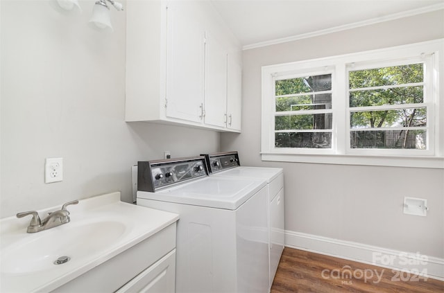 laundry area featuring sink, ornamental molding, cabinets, dark hardwood / wood-style floors, and separate washer and dryer