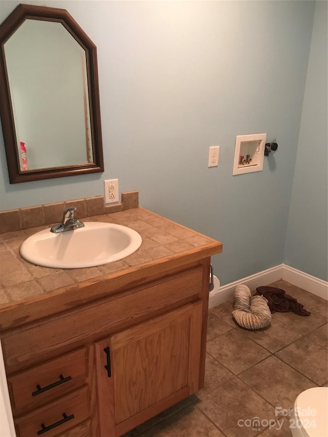 bathroom with vanity, tile patterned flooring, and toilet