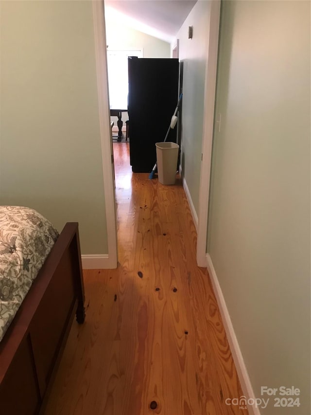 bedroom featuring lofted ceiling and light hardwood / wood-style floors