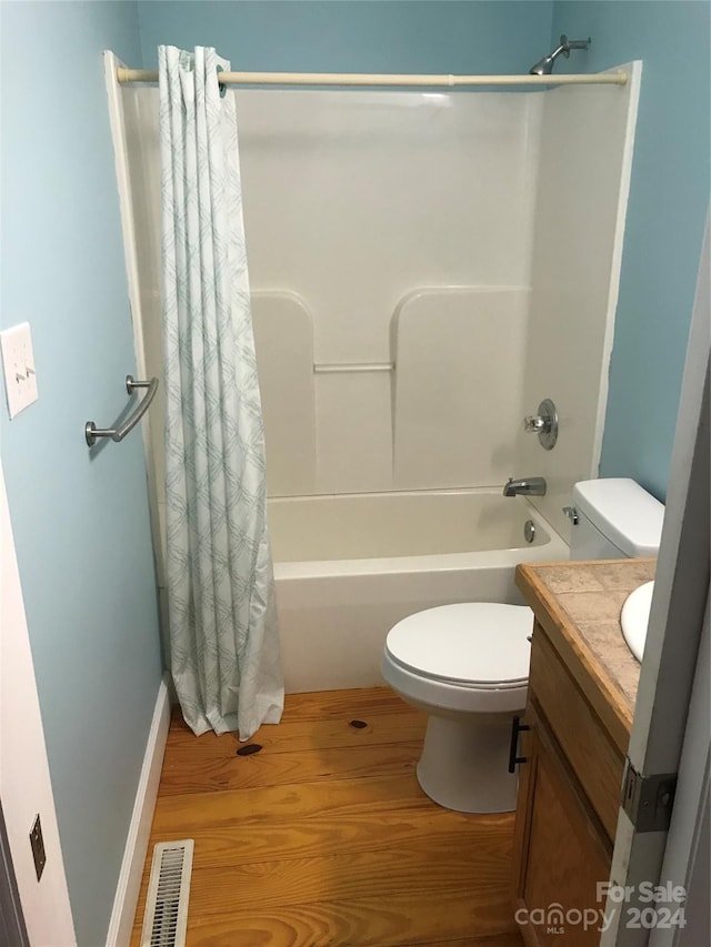 full bathroom featuring vanity, shower / bath combination with curtain, hardwood / wood-style flooring, and toilet