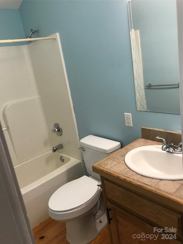 full bathroom featuring shower / washtub combination, wood-type flooring, vanity, and toilet