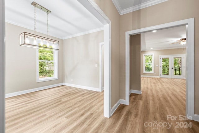 interior space with ornamental molding, light wood-type flooring, ceiling fan, and french doors