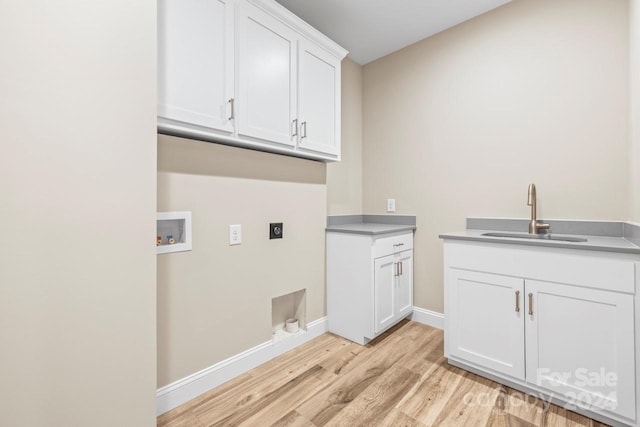 laundry area featuring sink, light hardwood / wood-style flooring, cabinets, hookup for a washing machine, and electric dryer hookup