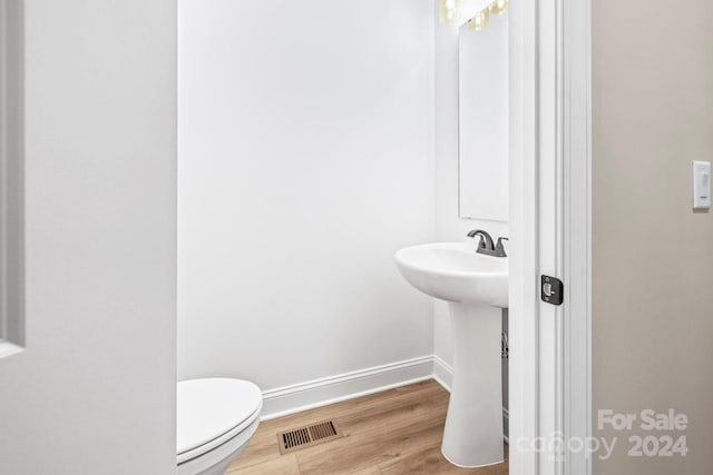 bathroom with wood-type flooring and toilet