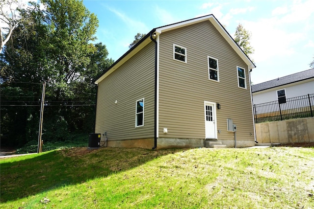 rear view of property with a lawn and central AC unit