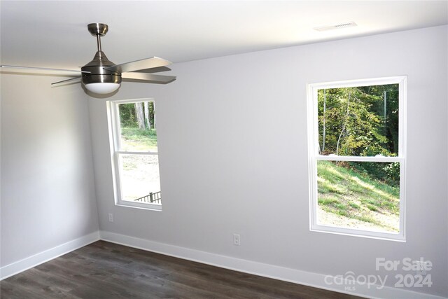 unfurnished room featuring ceiling fan, dark wood-type flooring, and a wealth of natural light