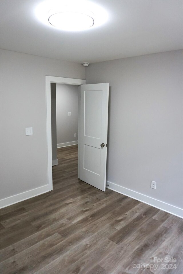 unfurnished room featuring dark hardwood / wood-style flooring