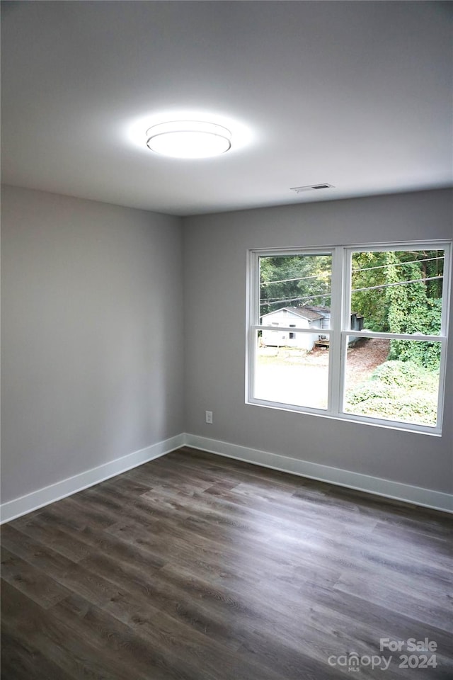 unfurnished room with dark hardwood / wood-style flooring