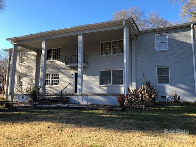 view of front of home with a balcony and a front yard