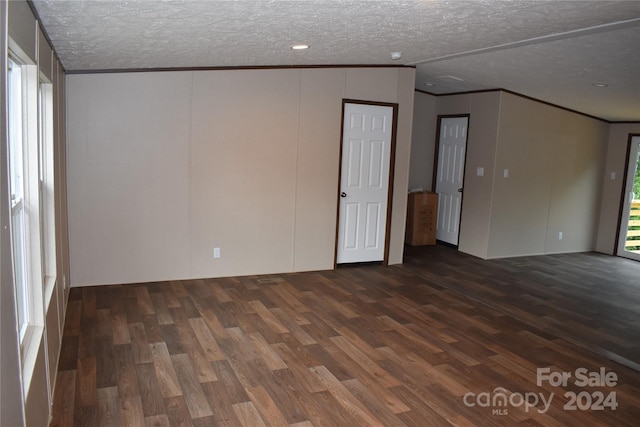 empty room featuring a textured ceiling and dark hardwood / wood-style floors