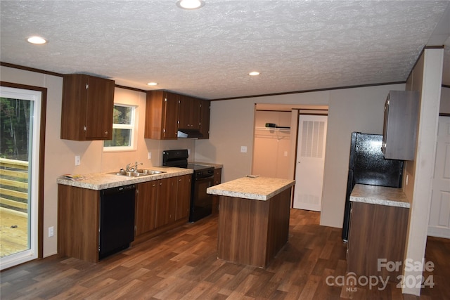 kitchen with a kitchen island, dark wood-type flooring, sink, crown molding, and black appliances