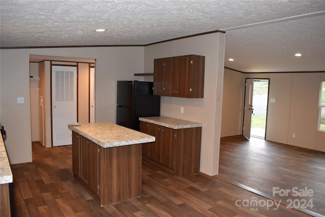 kitchen featuring black fridge, a kitchen island, dark hardwood / wood-style flooring, a textured ceiling, and vaulted ceiling