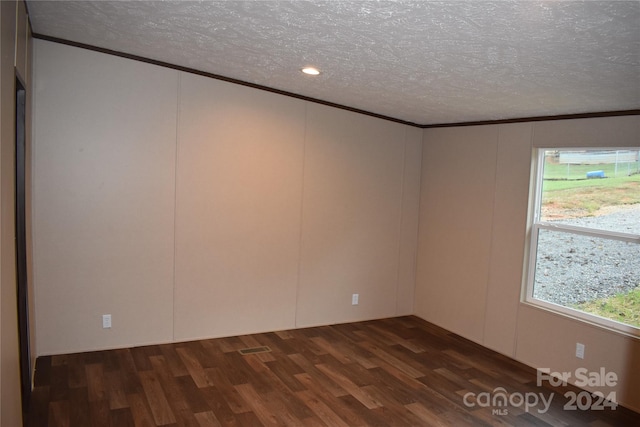 unfurnished room featuring ornamental molding, dark hardwood / wood-style floors, and a textured ceiling