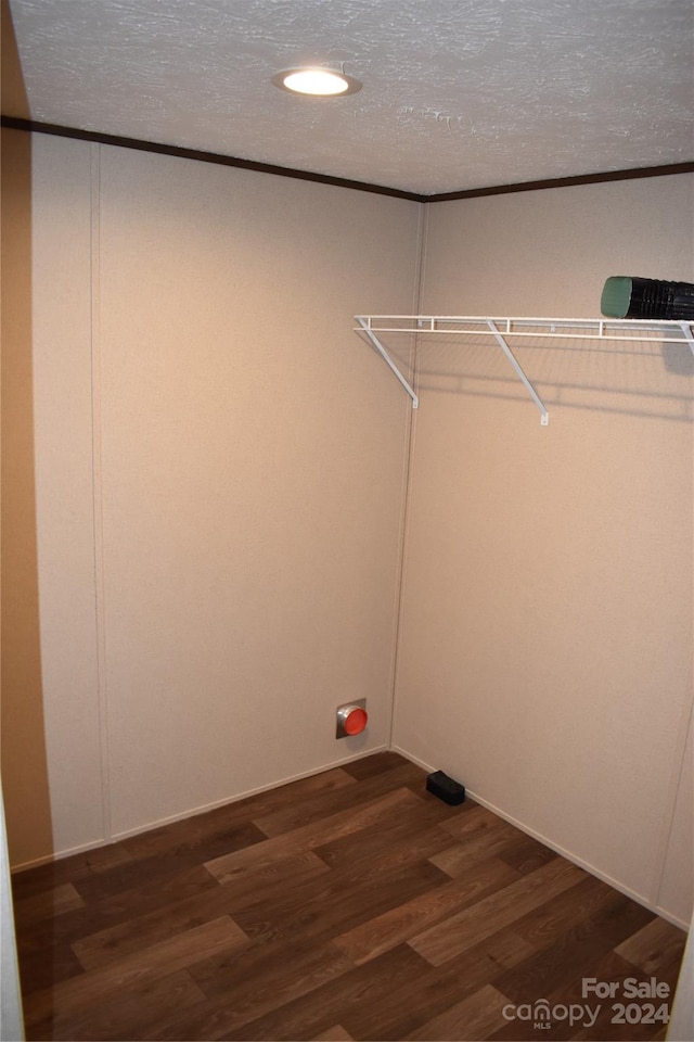 clothes washing area featuring a textured ceiling and dark hardwood / wood-style flooring