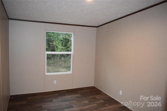 empty room with a textured ceiling, ornamental molding, and dark hardwood / wood-style floors