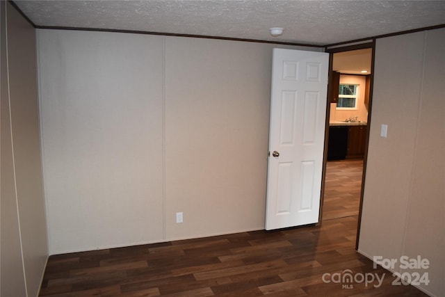 unfurnished bedroom with dark wood-type flooring and a textured ceiling