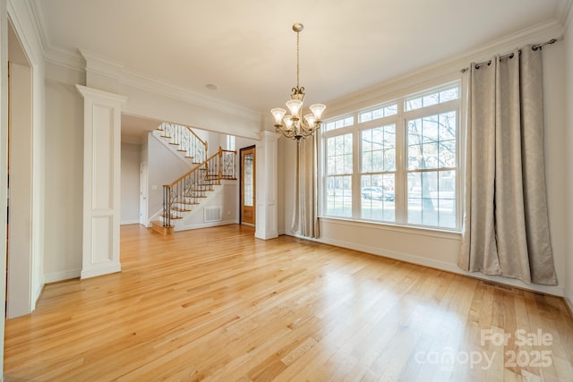 unfurnished room featuring ornamental molding, an inviting chandelier, and light hardwood / wood-style floors