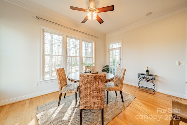 dining space with crown molding, hardwood / wood-style flooring, and ceiling fan