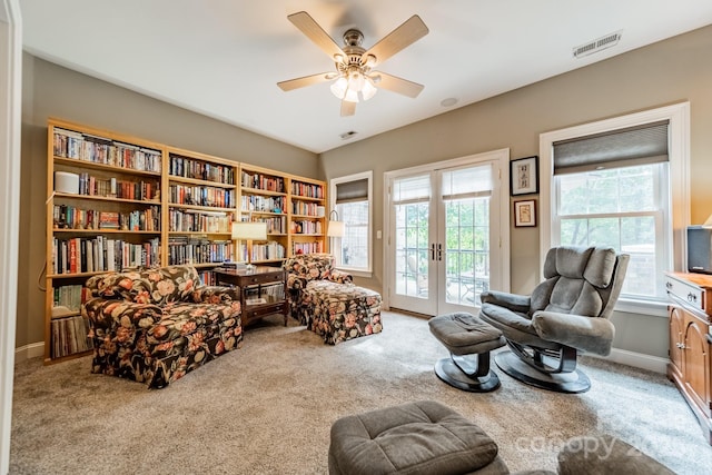 sitting room with carpet floors, french doors, and ceiling fan