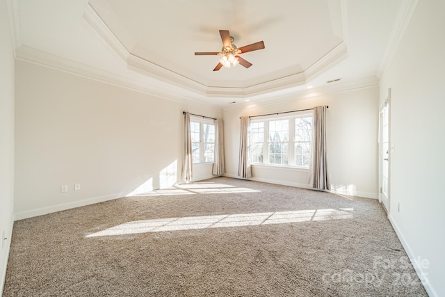 empty room with light carpet, a tray ceiling, ornamental molding, and ceiling fan