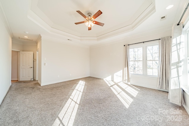 spare room with a raised ceiling, crown molding, and light carpet