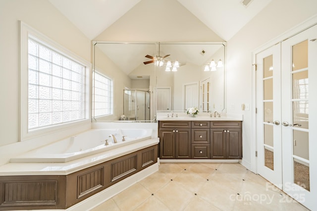 bathroom featuring independent shower and bath, vaulted ceiling, vanity, and french doors