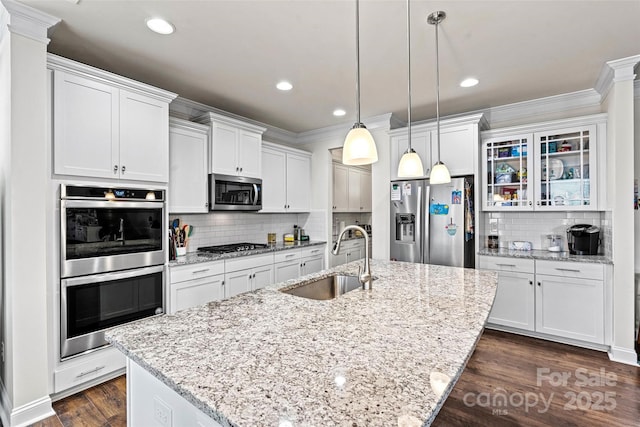 kitchen featuring an island with sink, stainless steel appliances, and sink