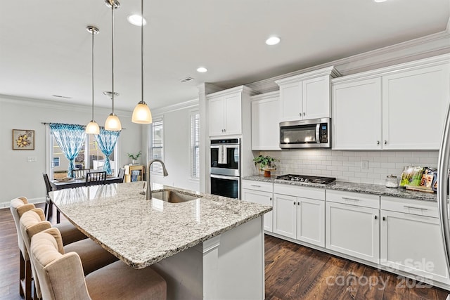 kitchen featuring white cabinetry, ornamental molding, stainless steel appliances, and a sink