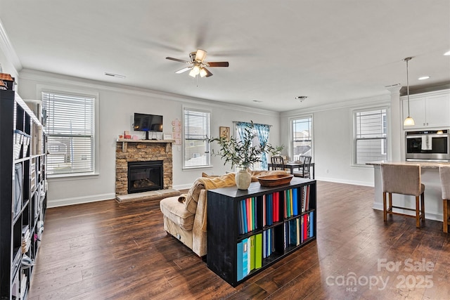 living area with dark wood-style floors, baseboards, a fireplace, and ornamental molding