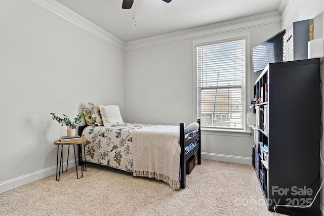 carpeted bedroom with ceiling fan, baseboards, and crown molding