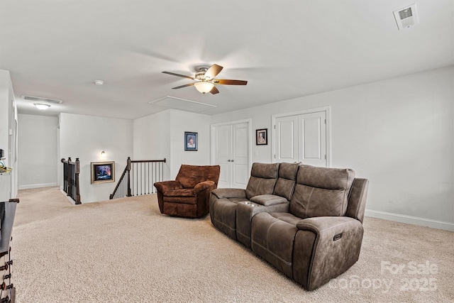 carpeted living area featuring baseboards, visible vents, and attic access