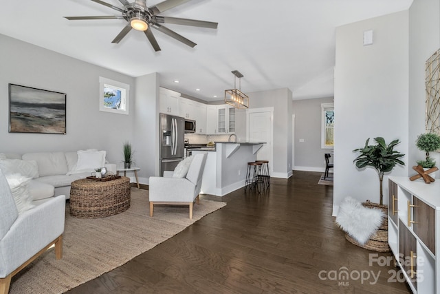 living room featuring ceiling fan and dark hardwood / wood-style flooring