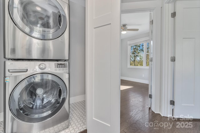 laundry room featuring stacked washing maching and dryer, dark hardwood / wood-style floors, and ceiling fan