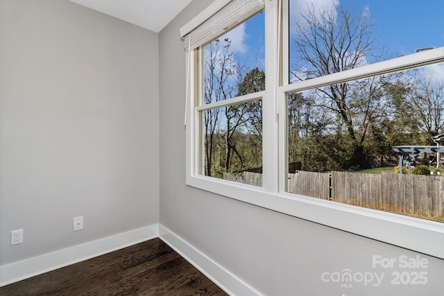 spare room with dark hardwood / wood-style floors and a healthy amount of sunlight