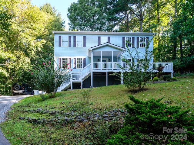 view of front of house featuring covered porch and a front lawn