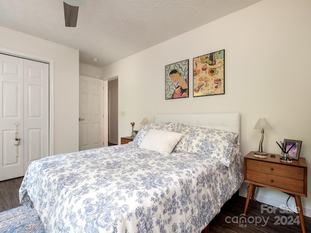 bedroom with ceiling fan, a closet, dark wood-type flooring, and a textured ceiling