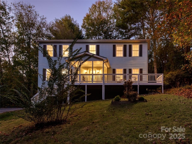 back of property featuring a wooden deck and a yard