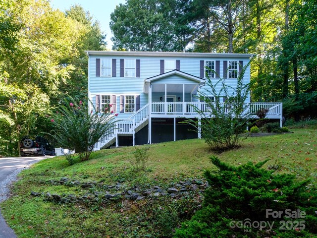 rear view of house featuring a yard, stairs, and a deck