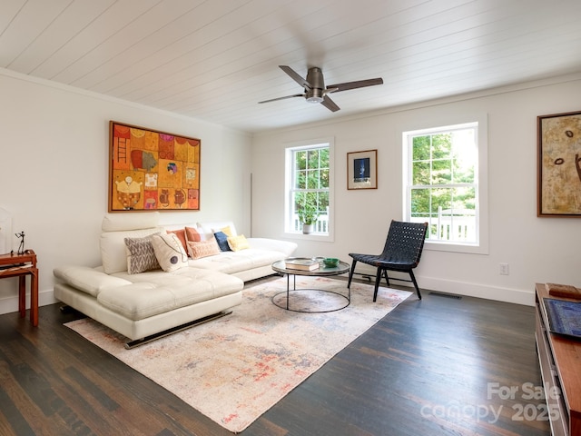 living area with visible vents, a ceiling fan, ornamental molding, baseboards, and dark wood-style flooring