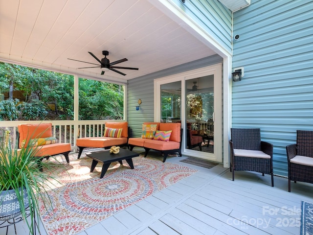 wooden deck with outdoor lounge area and ceiling fan