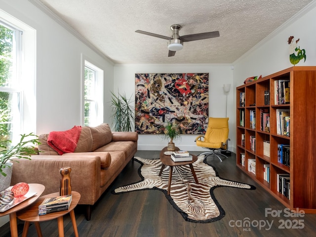 living room with ceiling fan, ornamental molding, wood finished floors, and a textured ceiling