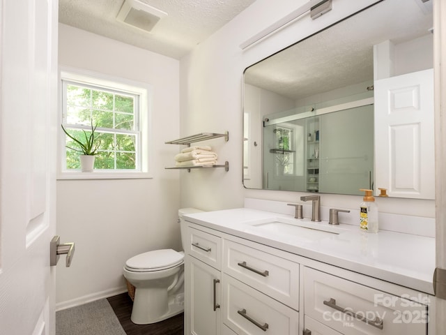 full bath with a textured ceiling, a stall shower, toilet, visible vents, and vanity