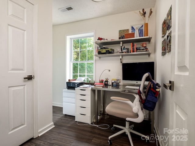 office area with baseboards, visible vents, and dark wood-type flooring