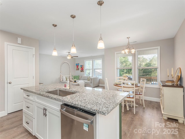 kitchen with sink, stainless steel dishwasher, an island with sink, decorative light fixtures, and white cabinetry