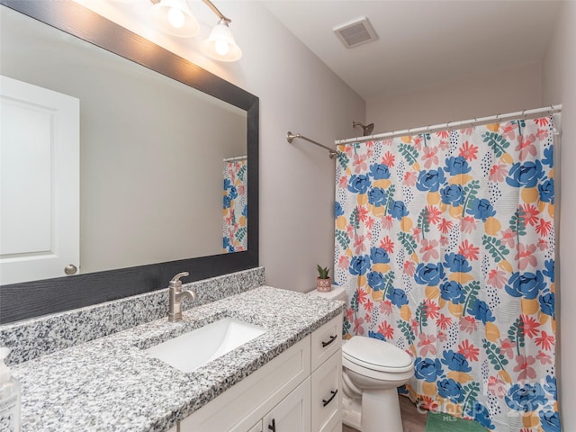 bathroom featuring a shower with curtain, vanity, and toilet