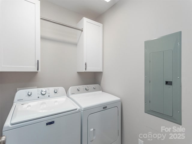 laundry room featuring cabinets, washing machine and dryer, and electric panel