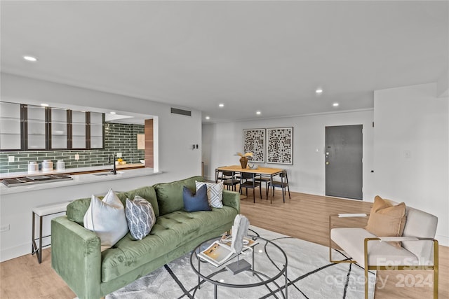 living room featuring ornamental molding and light hardwood / wood-style floors