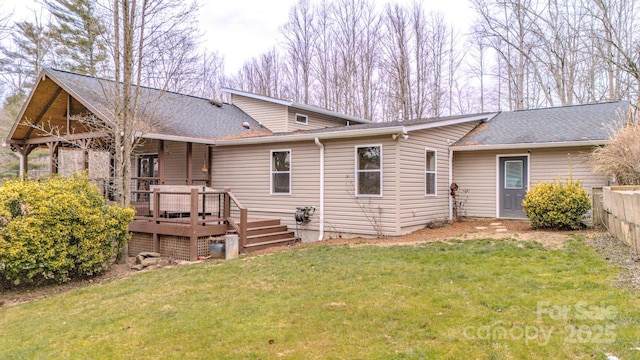 rear view of property with a deck and a lawn