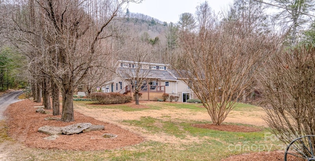 view of front of property featuring a mountain view and a front lawn