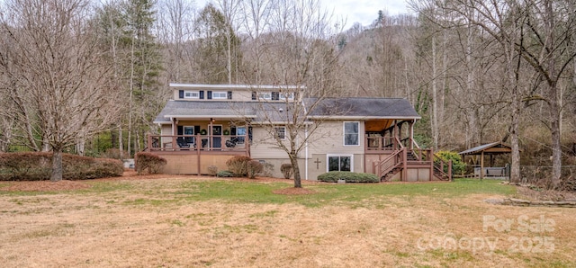 back of house featuring a carport, a yard, and a deck